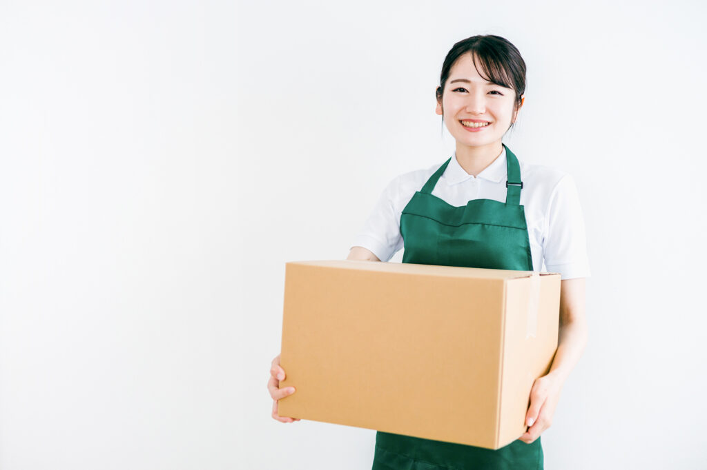 引っ越し用の段ボールを持ち上げる女性スタッフ