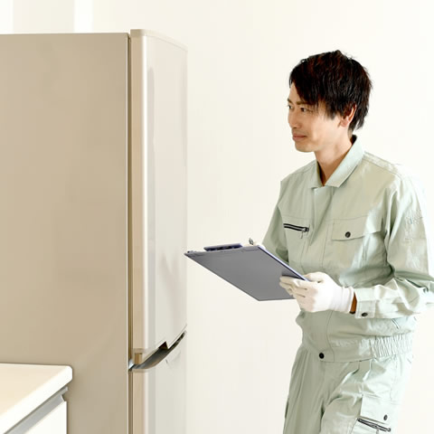 不要な冷蔵庫を運び出し見積もりを出す男性